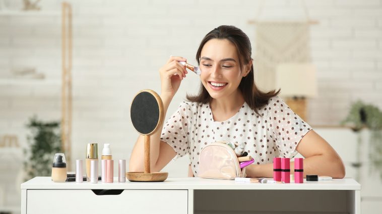 Cosmetics banner featuring makeup products like lipsticks, eyeshadows, foundations, and brushes for flawless application